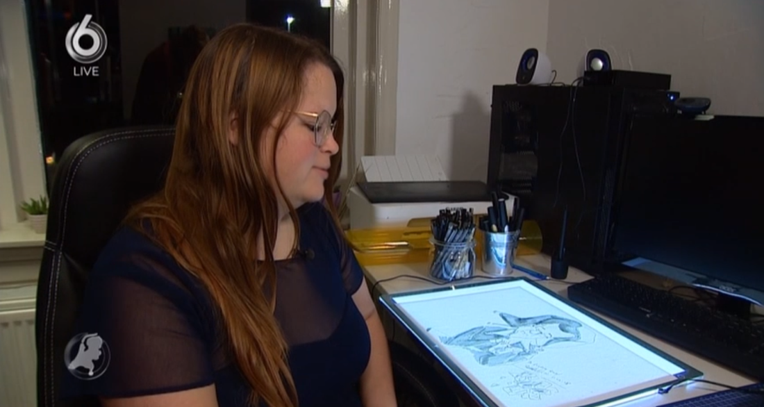 Screenshot van uitzending Hart van Nederland. Logo linksbovenin van SBS6 live. Renée zit in donkerblauw jurkje op bureaustoel, aan tafel, tekening van Rutte als joker te maken, op lichtbak.